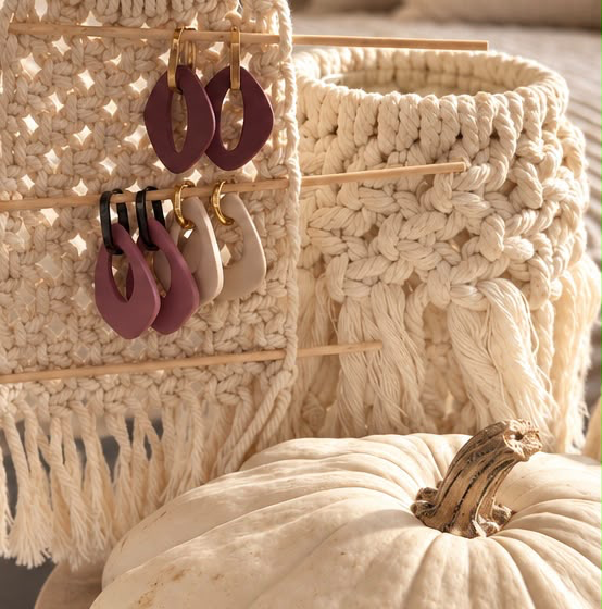Plum, rose and cream Monopops earrings on a macramé display beside a pale pumpkin