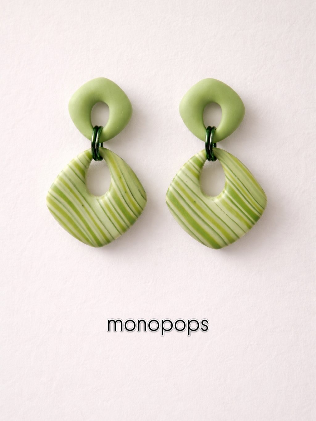 Pair of pale green striped earrings on a light background