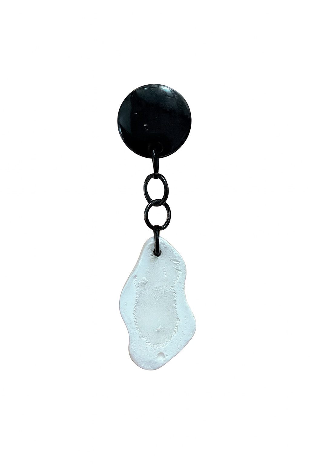 Black and white textured earring on a plain background