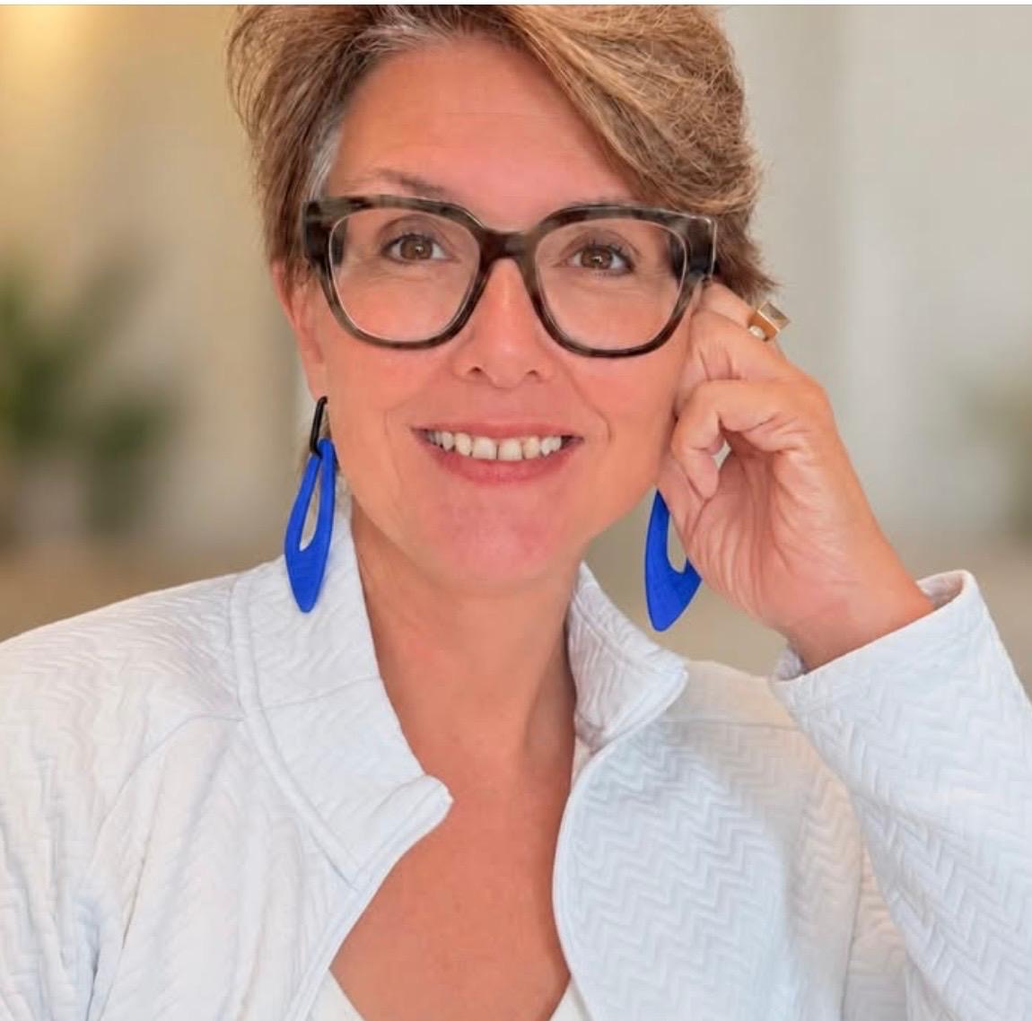 Woman wearing vivid blue Monopops earrings and glasses