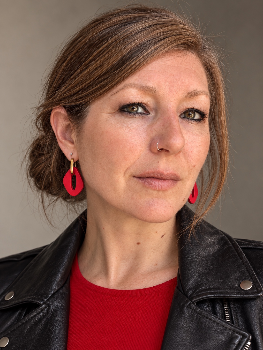 Woman wearing red Monopops earrings, a black leather jacket and a red top