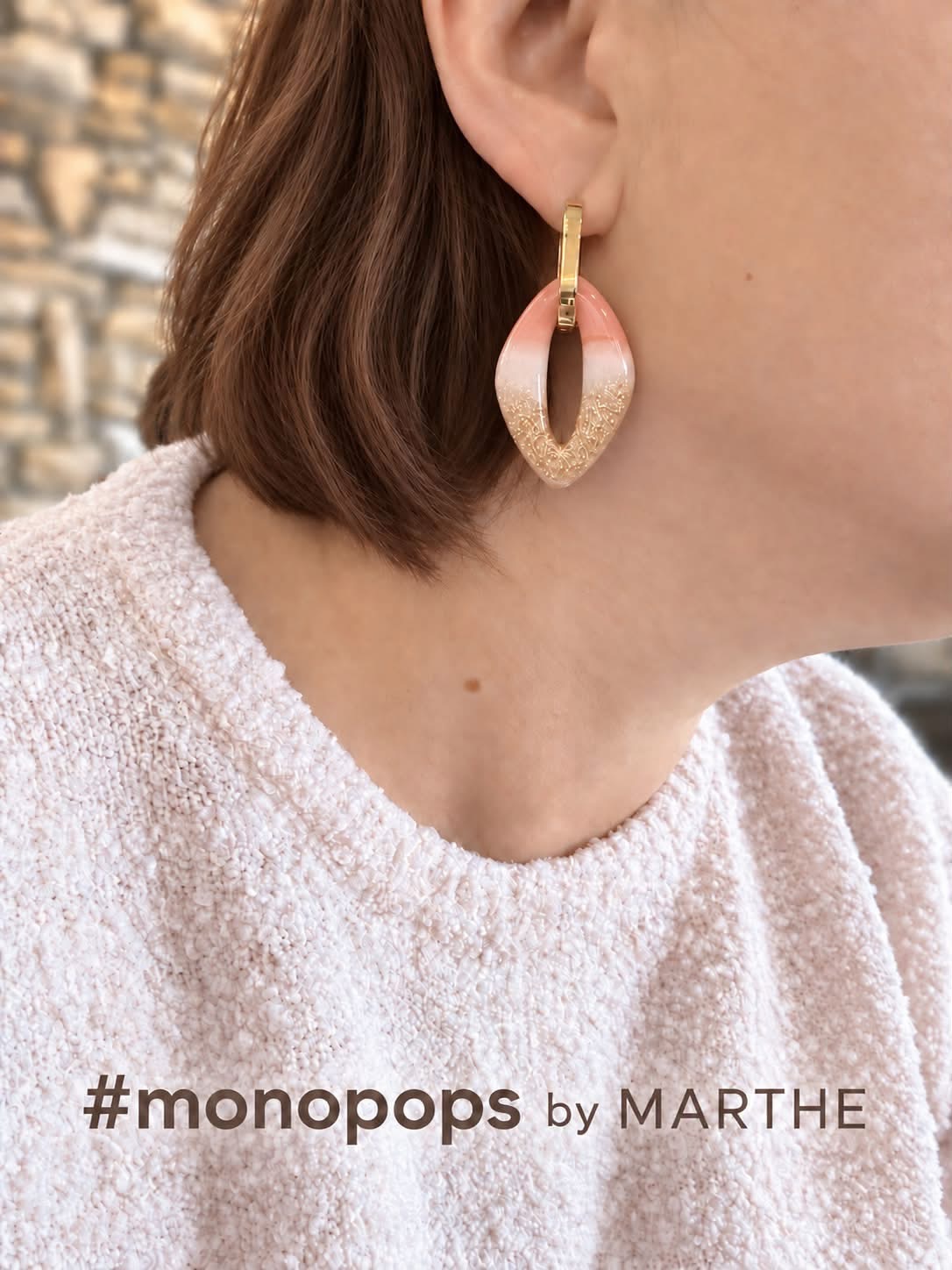 Close-up of a pink and gold Monopops earring